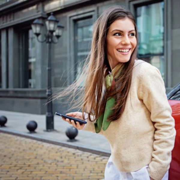 Une jeune femme attend que sa voiture électrique soit chargée